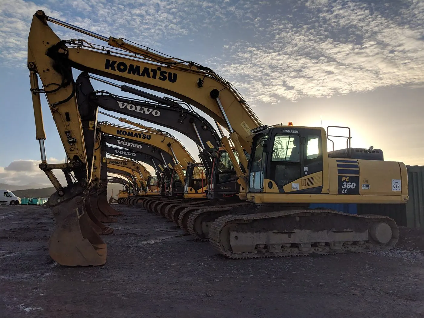 Excavators lined up on site at sunrise